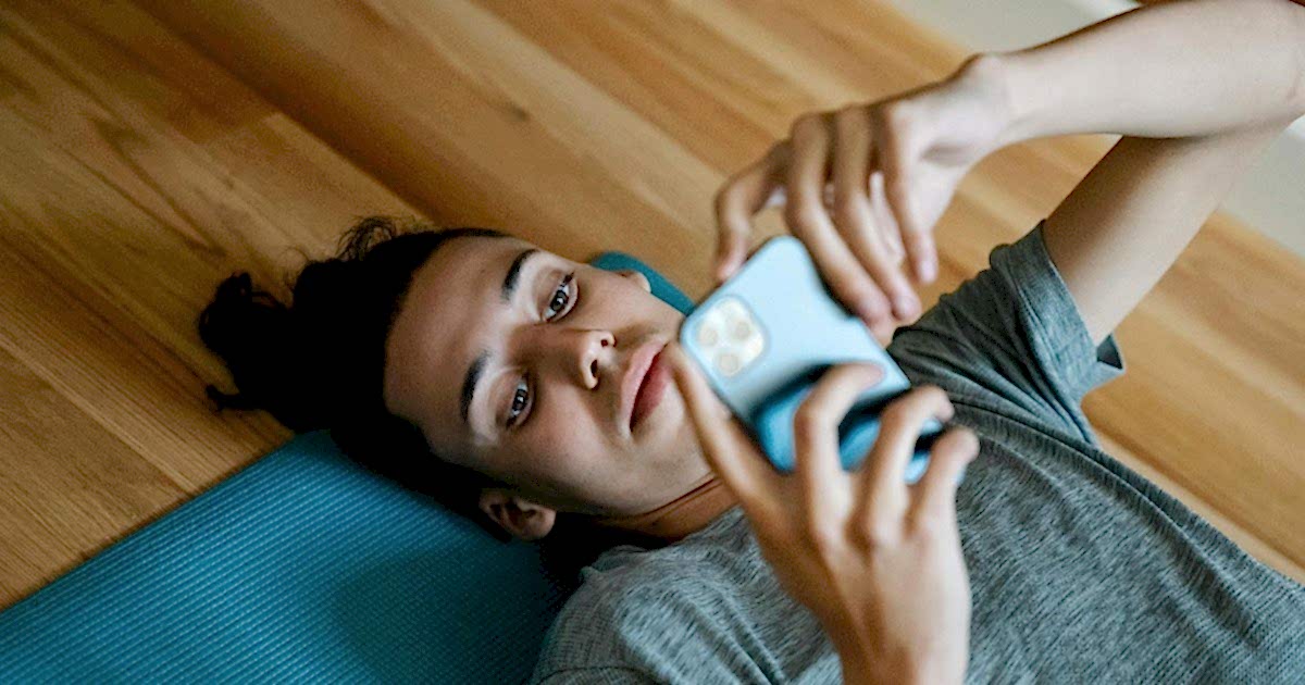 Digital Detox: Man Using a Phone on a Yoga Mat